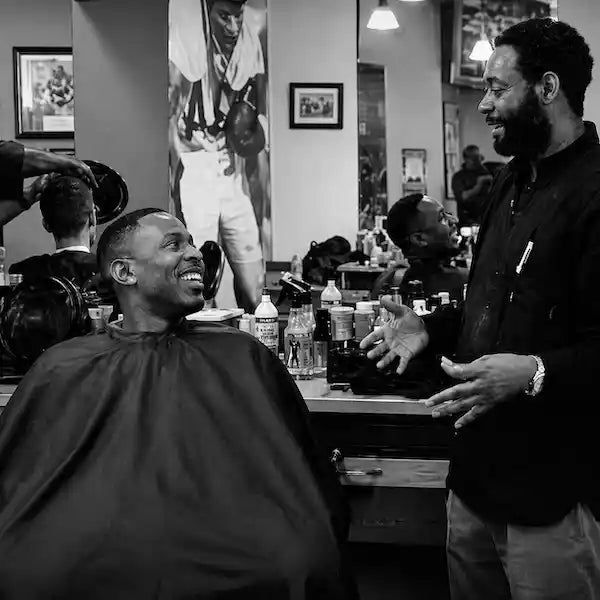 A master barber asking a customer about their haircut