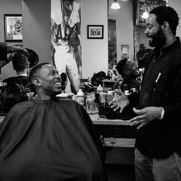 A master barber asking a customer about their haircut